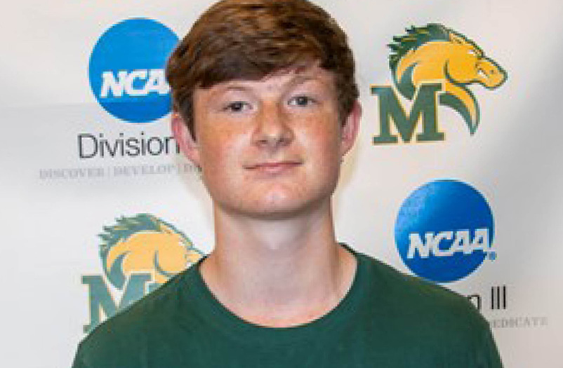 A young man poses in front of a Marywood Pacers backdrop